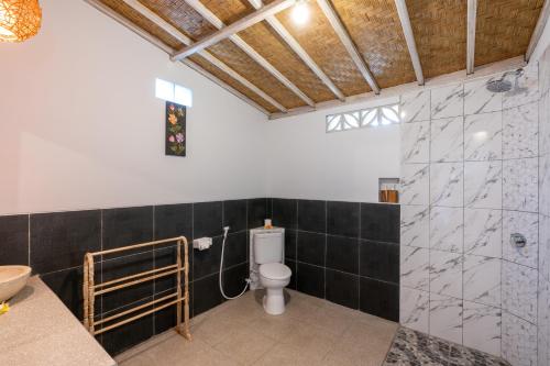 a bathroom with a toilet and a sink and a shower at Le Biu garden View in Nusa Lembongan