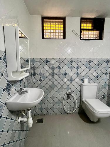 a bathroom with a sink and a toilet and a mirror at Easy Living Guesthouse - Close to Margao, near Varca Beach, Varca in Varca