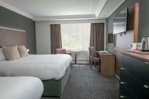 a hotel room with two beds and a table and a kitchen at Best Western Plough and Harrow Hotel in Birmingham