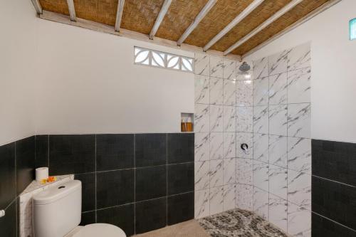 a bathroom with a toilet and a shower at Le Biu garden View in Nusa Lembongan