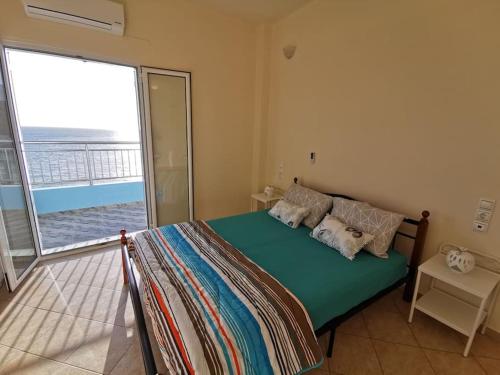 a bedroom with a bed with a view of the ocean at Amazing house Erato in front of the Sea - South Creta in Paránimfoi