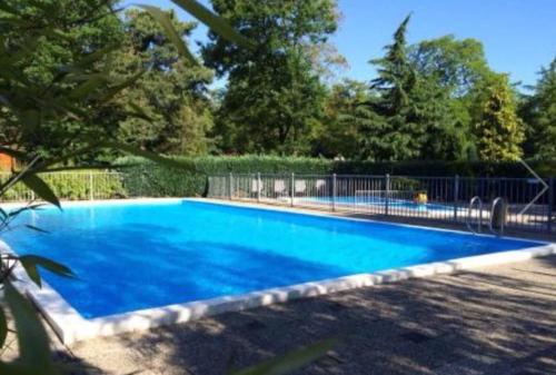 a large blue swimming pool in a yard at COSY Holiday Home in Harderwijk
