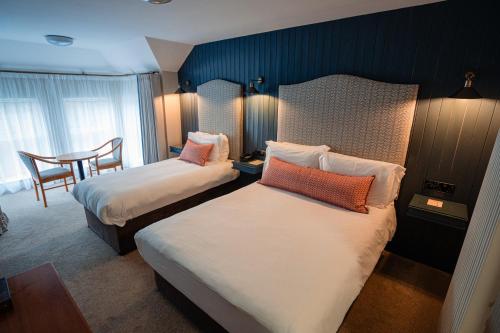 Cette chambre comprend 2 lits et une table. dans l'établissement McGrory's Hotel, à Culdaff