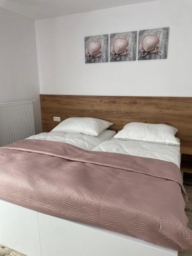 a bedroom with a large bed with two pillows at Rado Apartments in Svit