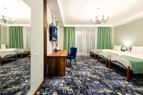 um quarto de hotel com duas camas e uma televisão em MirOtel em Shymkent