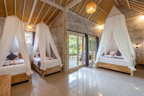 a bedroom with two beds with mosquito nets in it at Le Biu garden View in Nusa Lembongan