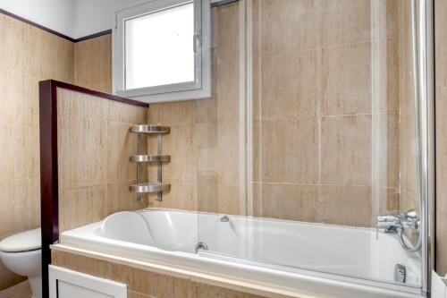 a bathroom with a bath tub and a toilet at Antiga Esquerra de lEixample 1br w balcony BCN-81 in Barcelona