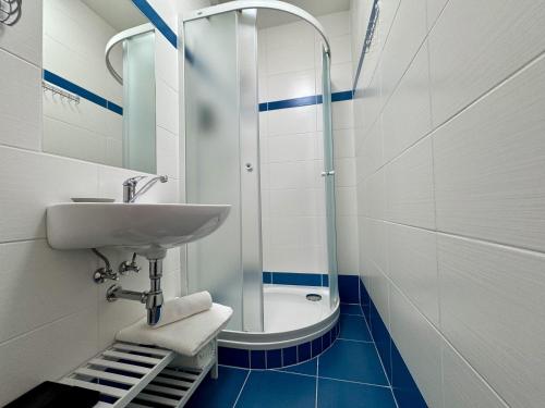 een badkamer met een wastafel en een douche bij Ubytování ve městě Velešín in Velešín