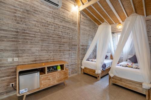 a room with two beds and a tv in it at Le Biu garden View in Nusa Lembongan