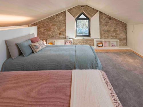 Un dormitorio con una cama grande y una ventana en Casa Da Romeira Country House, en Freixieiro de Soutelo