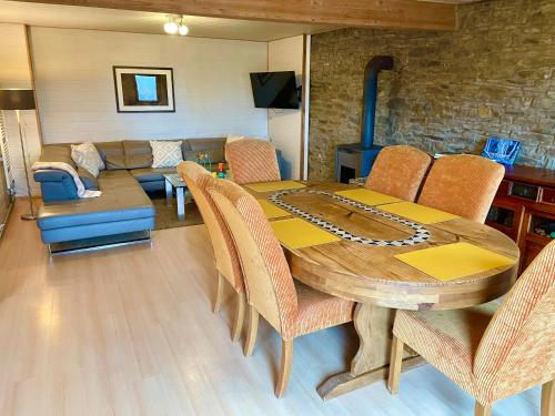 ein Esszimmer mit Tisch und Couch in der Unterkunft Revival Ranch Ferienwohnung in Büllingen