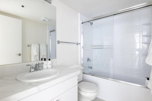 La salle de bains blanche est pourvue d'un lavabo et de toilettes. dans l'établissement South Beach 2br w tennis nr public transport SFO-1663, à San Francisco