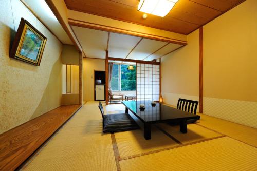 a living room with a table in a room at Ryokan Tanigawa in Minakami