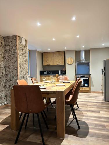 une cuisine et une salle à manger avec une table et des chaises en bois dans l'établissement Gîte du Marcotton, à Arbois