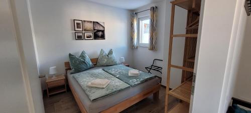 a small bedroom with a bed and a window at Appartement Petersberg in Aich