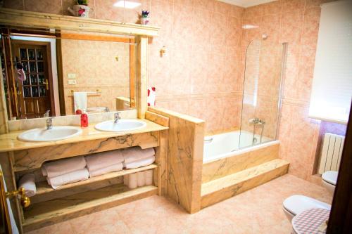 a bathroom with two sinks and a tub and a shower at 4 bedrooms house with private pool jacuzzi and enclosed garden at Magan in Cuntis