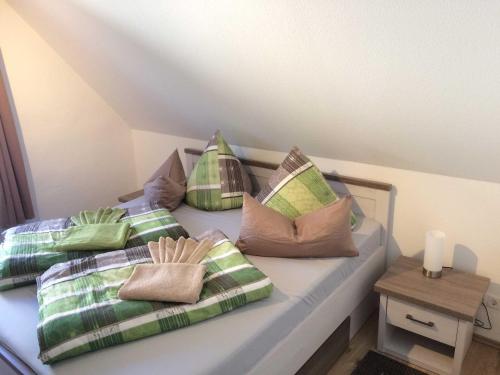 una cama con varias almohadas encima en Ferienhaus Urlaubundmeer, en Bad Doberan