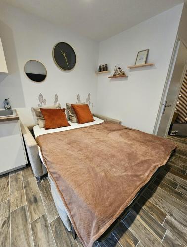 - une chambre avec un grand lit et une horloge murale dans l'établissement Appartement Cocooning, à Fréjus