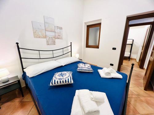 a blue bed with towels on it in a room at Casa Carlotta Apartments in Terrasini