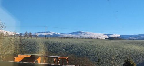 uma mesa de piquenique num campo com montanhas cobertas de neve em Lakes and Eden Valley. Thornhill Cabin em Long Marton