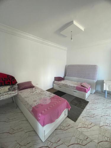 a bedroom with two beds and a couch at Summer Rental in Nabeul