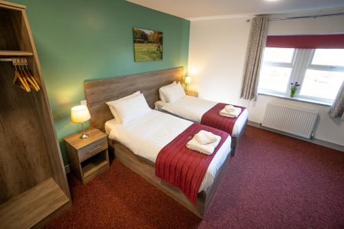 um quarto de hotel com duas camas e uma janela em Belvedere Hotel and Golf em Bridlington