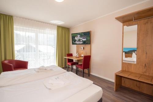 pokój hotelowy z łóżkiem i stołem w obiekcie Burghotel Aschau w mieście Aschau im Chiemgau