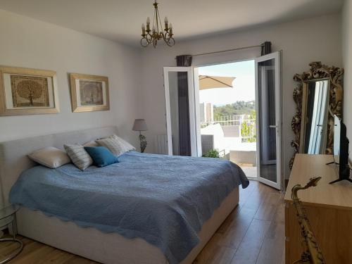 a bedroom with a bed and a large window at Family Home - Between Monaco, Menton & Gorbio - Beautiful in Gorbio