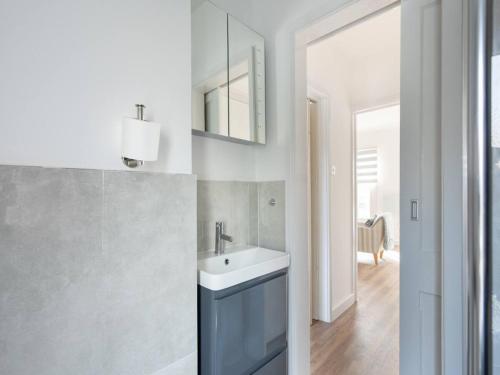 a bathroom with a sink and a mirror at Stylish Flat Centrally Located I Pass The Keys in Twyford