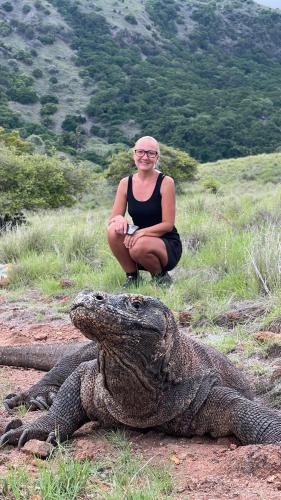 a woman is sitting next to an alligator at Jhuna Komodo Homestay in Komodo