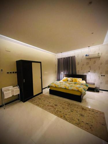 a large bedroom with a bed and a mirror at Abha Jacaranda in Abha