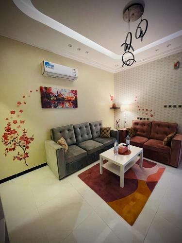 uma sala de estar com um sofá e uma mesa em Abha Jacaranda em Abha