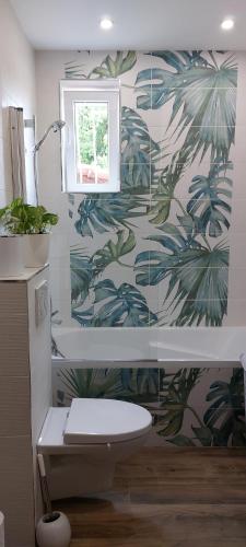 a bathroom with a toilet and a tropical wallpaper at Family Home - Between Monaco, Menton & Gorbio - Beautiful in Gorbio