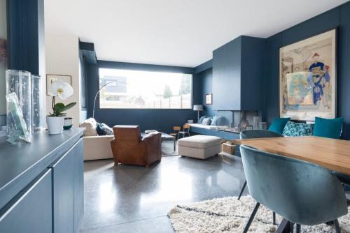 ein Wohnzimmer mit blauen Wänden sowie einem Tisch und Stühlen in der Unterkunft Pleasant Family house with swimming pool in Bordeaux