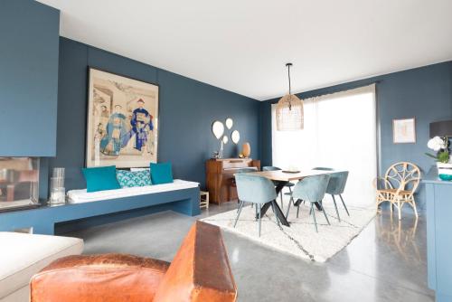 a living room with blue walls and a table and chairs at Pleasant Family house with swimming pool in Bordeaux