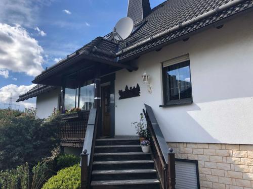 a white house with stairs leading to the door at Ferienwohnung Fischer Reif 