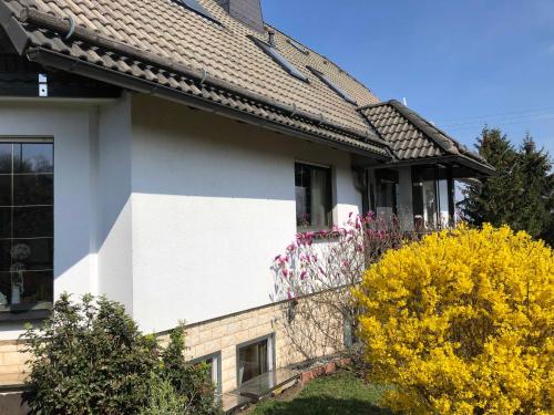 a white house with a window and yellow flowers at Ferienwohnung Fischer Reif 