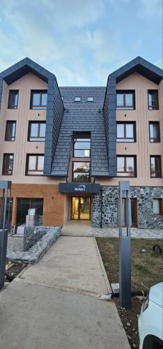 un grand bâtiment avec un toit noir dans l'établissement DM apartman Divcibare, à Divčibare