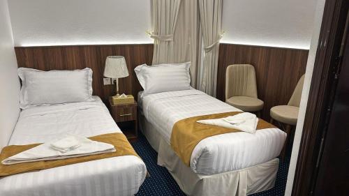 two beds in a hotel room with towels on them at ظلال النزلاء in Jarwal
