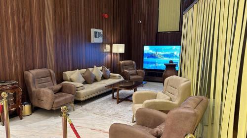 a living room with a couch and chairs and a tv at ظلال النزلاء in Jarwal
