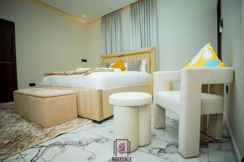 a bedroom with a bed and a chair in it at 2-BEDRM URBAN Elegance at The Rosedale Apartments in Accra