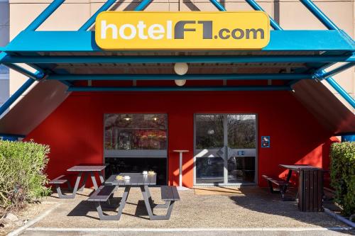a hotel förör restaurant with picnic tables in front of it at hotelF1 Rungis Orly in Rungis