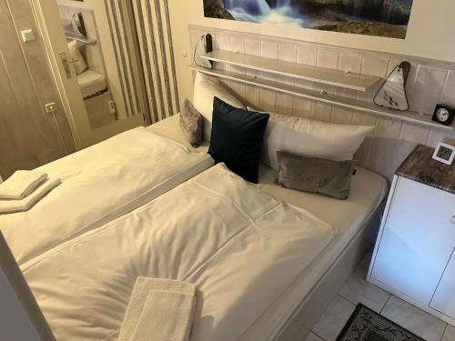 1 cama blanca grande con 4 almohadas en Kaminflair en Altenau