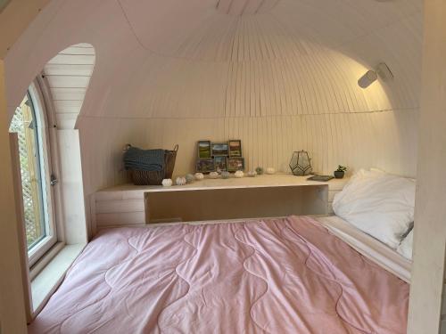 a small bedroom with a pink bed in a room at Clotted Cream -Lydcott Glamping, Cornish Sea Views in Looe