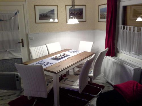 a dining room table with white chairs around it at Heidi`s Ferienhaus in Mittenaar