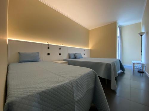 a bedroom with two beds and a window at White Pico Lodge in São Roque do Pico