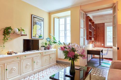 una sala de estar con TV y un jarrón de flores en Adosado con jardín en el centro de A Coruña en A Coruña