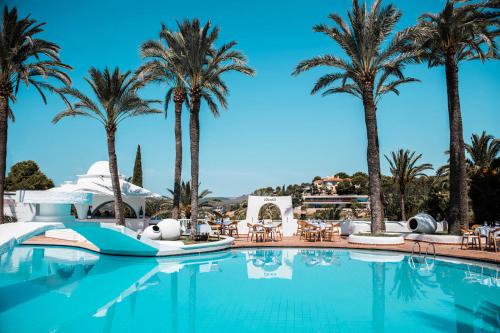 a pool at a resort with palm trees at Hilton Mallorca Galatzo in Paguera