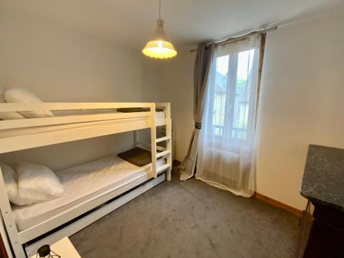 une chambre avec deux lits superposés et une fenêtre dans l'établissement Maison Noëlle, à Montignac