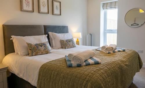 a bedroom with a large bed with towels on it at Peasgood in Spilsby